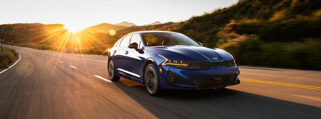 Blue 2021 Kia K5 driving