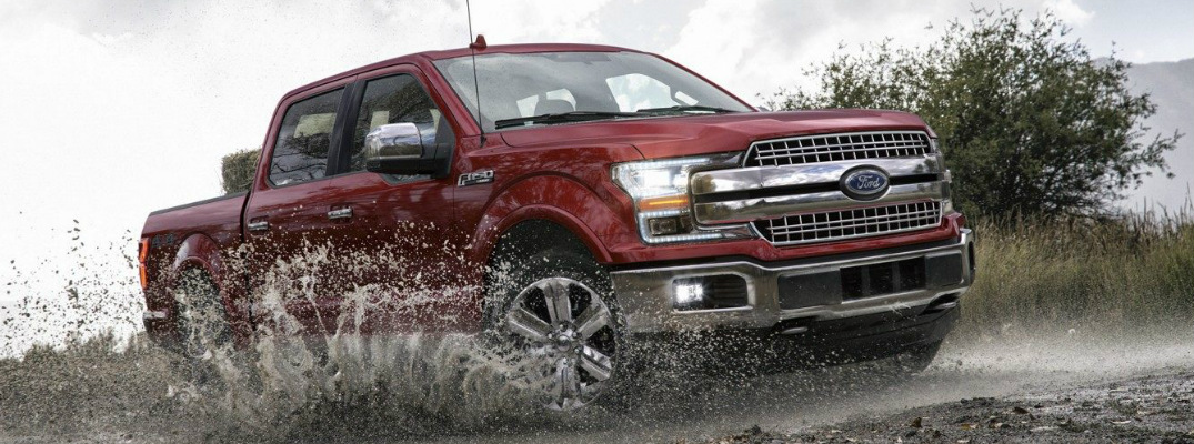 Red 2018 Ford F-150 Driving Through a Puddle