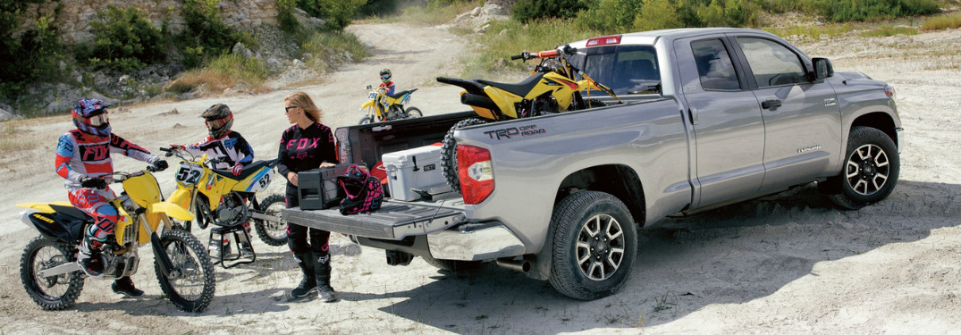 People Riding Motorbikes next to a 2018 Toyota Tundra