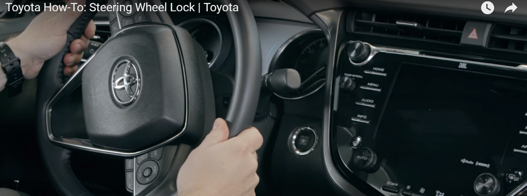 Man Turning a Steering Wheel on a Toyota Vehicle