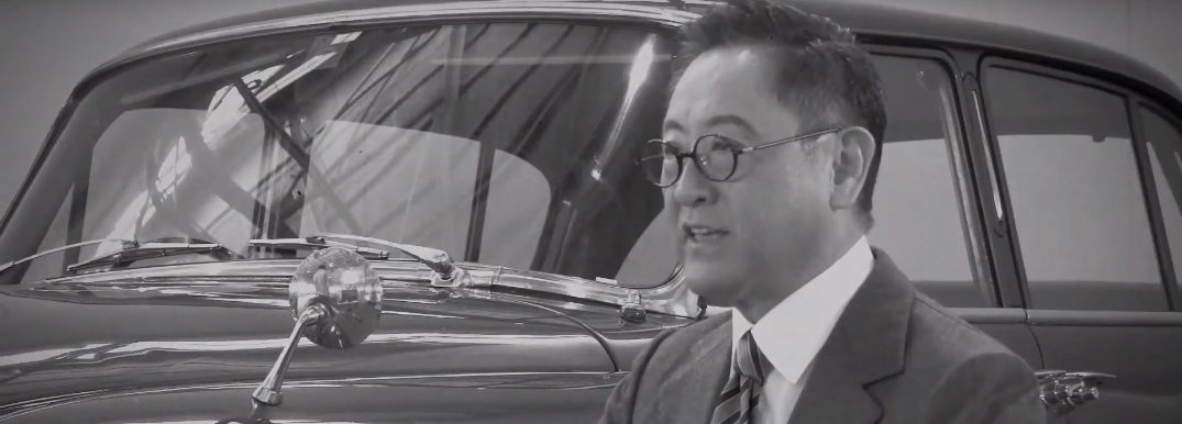 Toyota Founder Kiichiro Toyoda Sitting Next to a Toyota Car