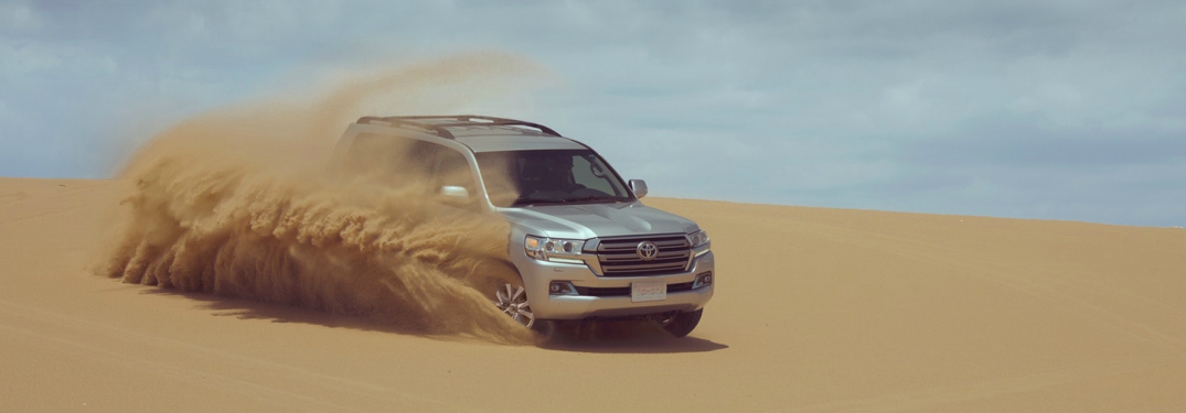 silver 2018 Toyota Land Cruiser driving in the sand