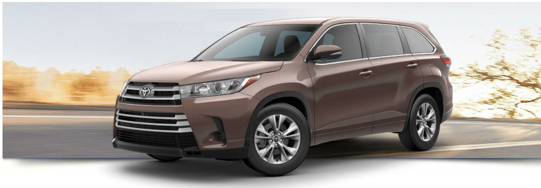 2018 Toyota Highlander LE exterior front fascia and drivers side with blurred road and tree