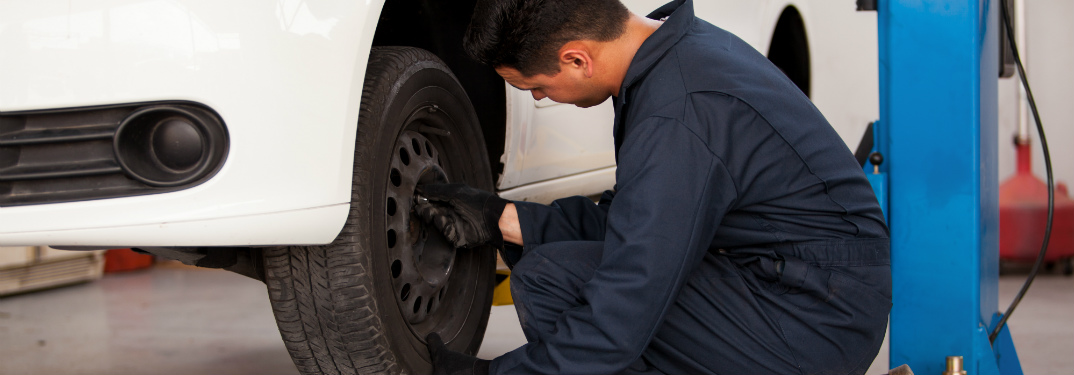 Mechanic working on the tire of a raised car