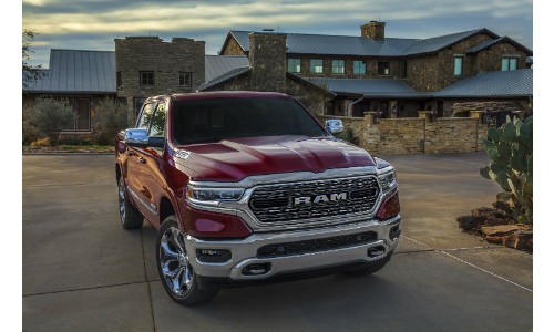 2019 Ram 1500 exterior shot parked outside fancy brick house with cloudy sky