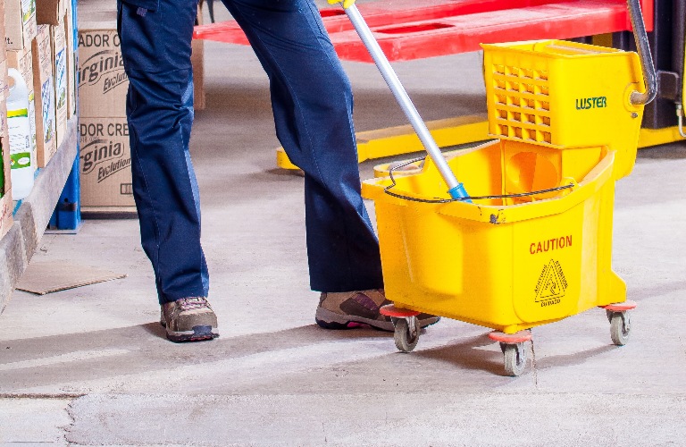 Person's legs and bucket with mop