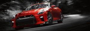 Red 2018 Nissan GT-R driving on dark road