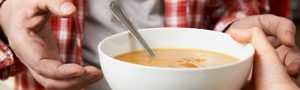 man receiving a bowl of soup