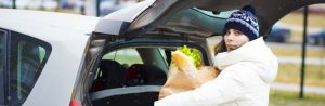 woman putting food in trunk