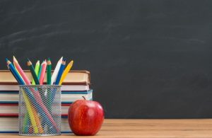 An apple beside a stack of books