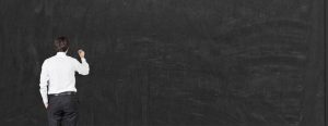 A teacher writing on a blackboard
