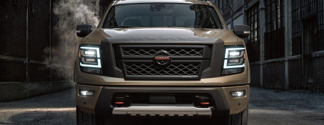 Front view of a 2022 Nissan Titan backdropped by a smoke-filled alley