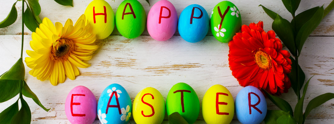 happy easter written on many color painted easter eggs on a wood nature carved table top counter