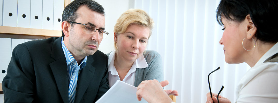 Three people in a room inspecting an insurance claim