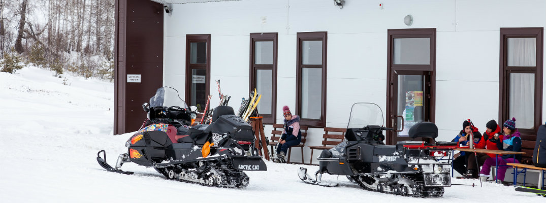 Snowmobiles gathered outside a building