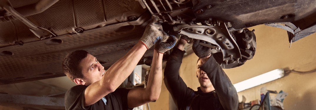 Technician and mechanic working on car