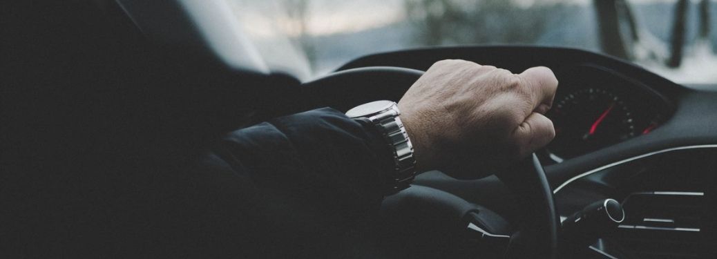 Man with his hands on the steering wheel of a car