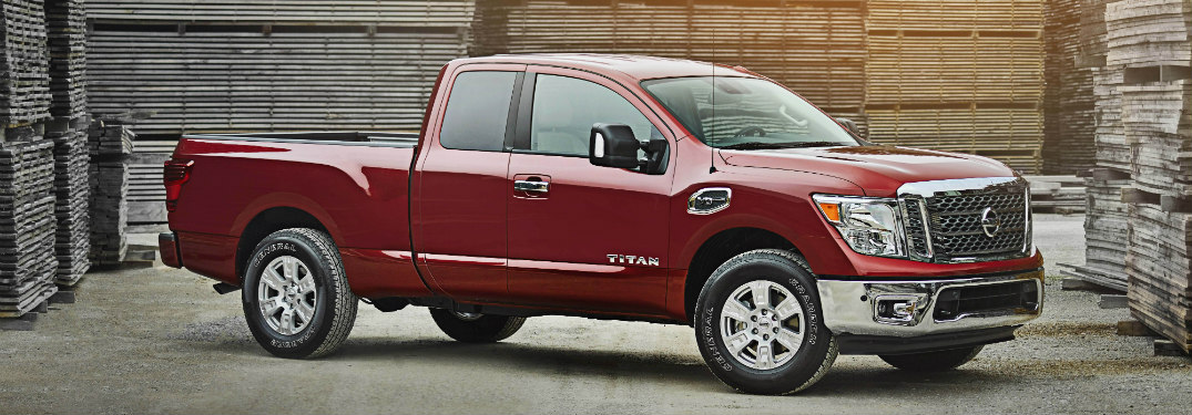 red 2018 nissan titan surrounded by stacks of wooden pallets