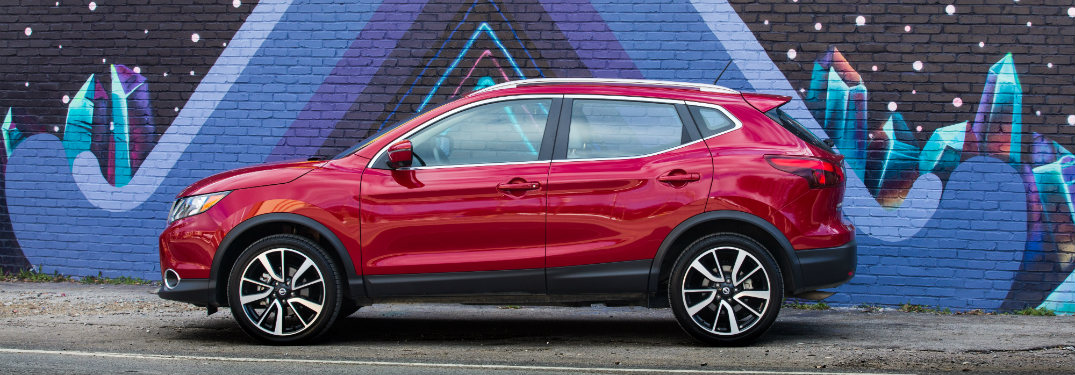 red 2018.5 nissan rogue sport side view against wall mural