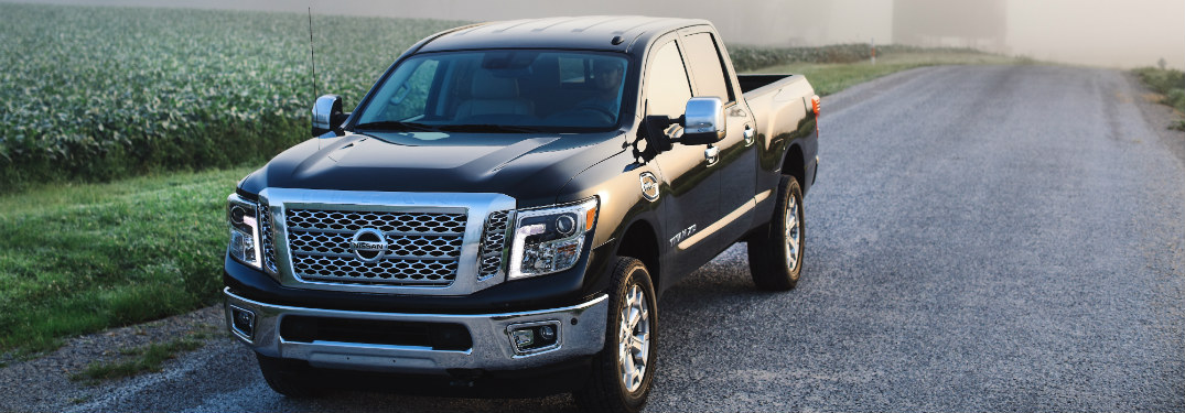 black 2018 nissan titan xd driving down gravel farm road