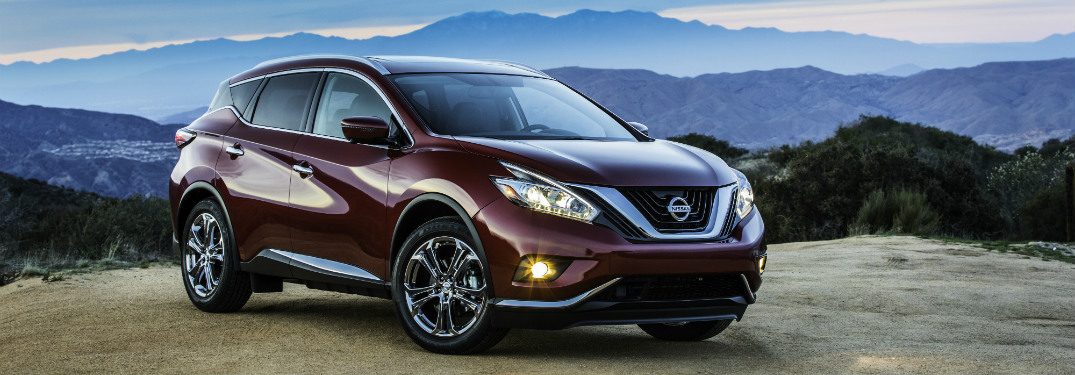 maroon 2018 nissan murano on edge of cliff with mountain range behind it