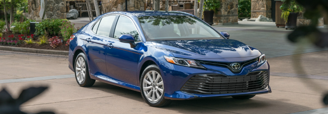 blue 2018 toyota camry in driveway of mansion
