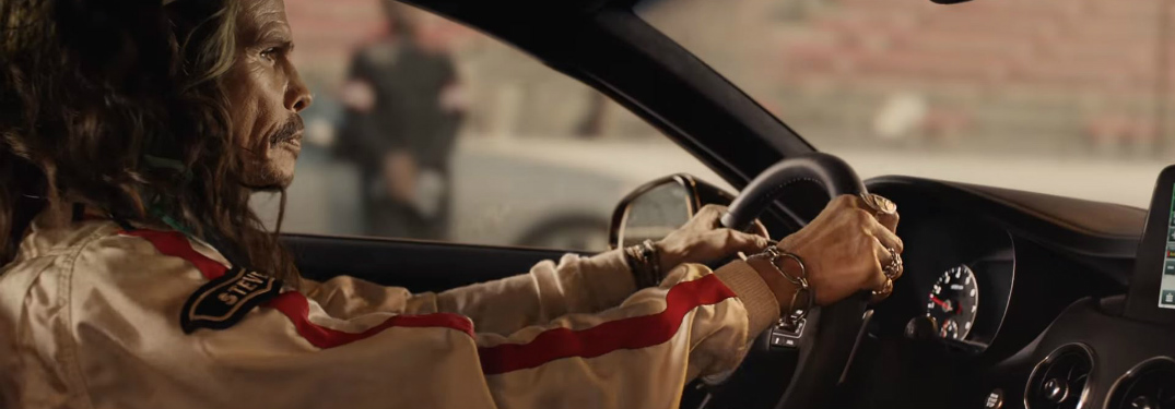 Steven Tyler behind the wheel of the 2018 Kia Stinger in commercial