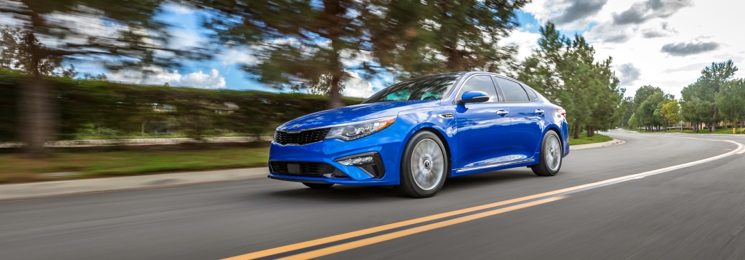 Blue 2019 Kia Optima driving on open road