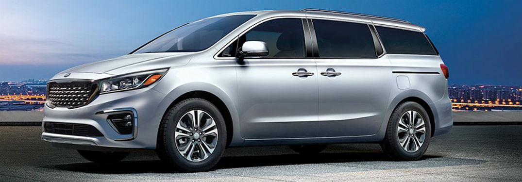 2020 Kia Sedona silver exterior driver side front fascia night city background