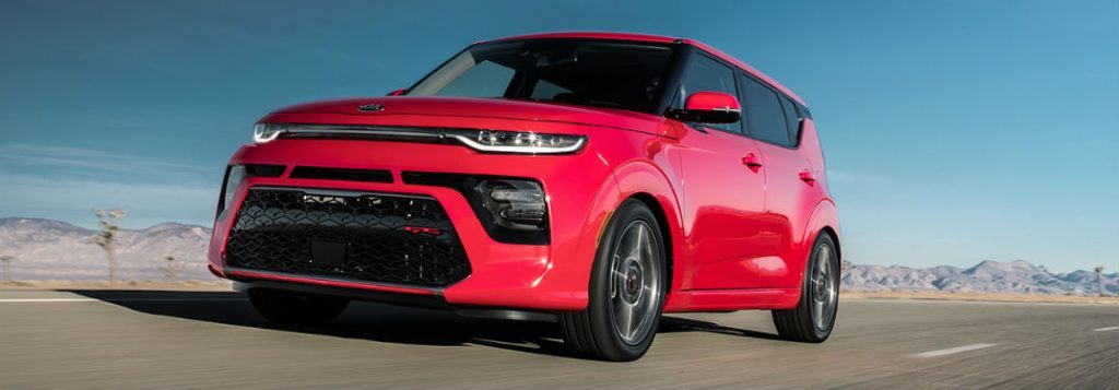 2020 Kia Soul red exterior front fascia driver side driving past joshua trees and mounds