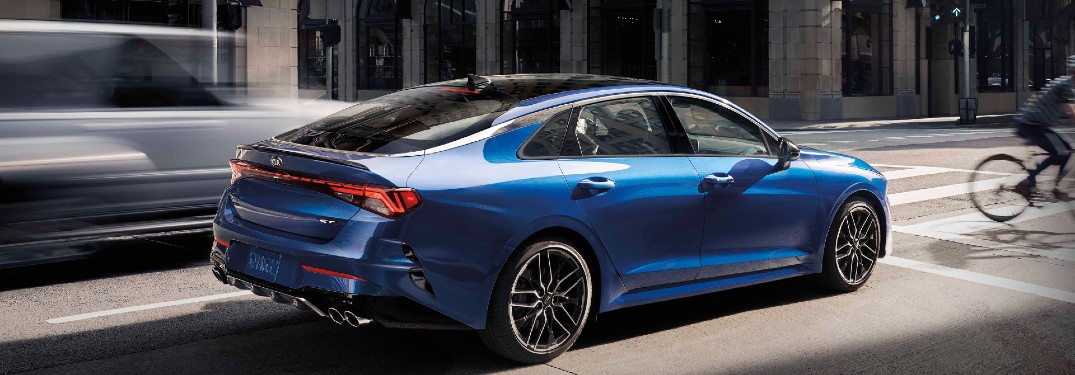 2021 Kia K5 blue exterior rear fascia passenger side driving in city