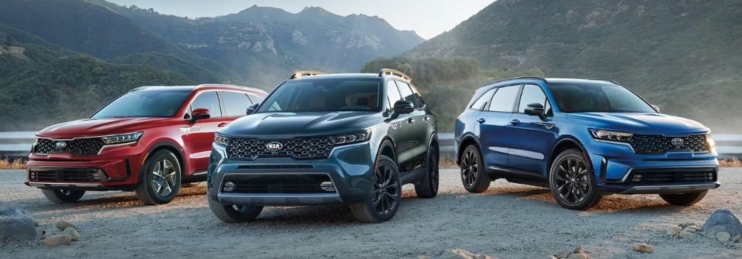 Three 2021 Kia Sorento models parked side by side in front of a lake