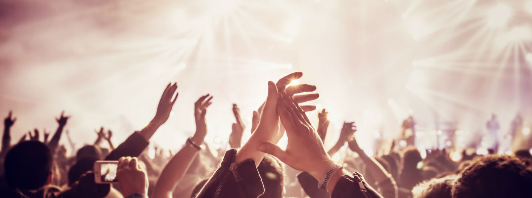 Crowd in front of stage with hands up