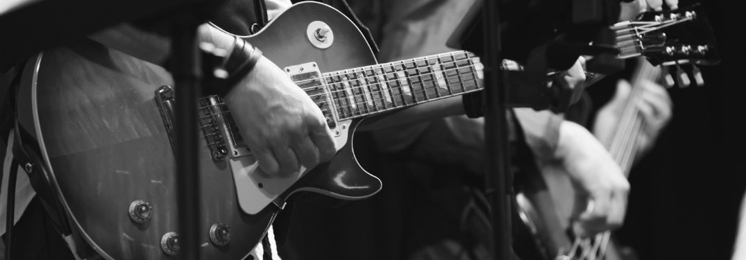close up of hands playing guitar