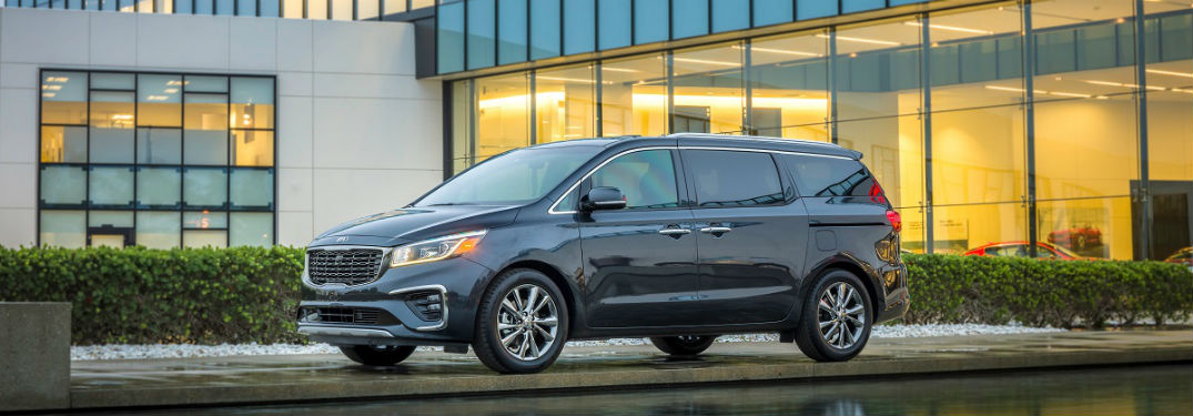 kia sedona parked in front of a dealership