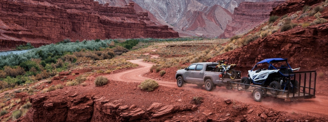 Gray 2019 Toyota Tacoma on a Desert Trail Towing a Trailer with ATV