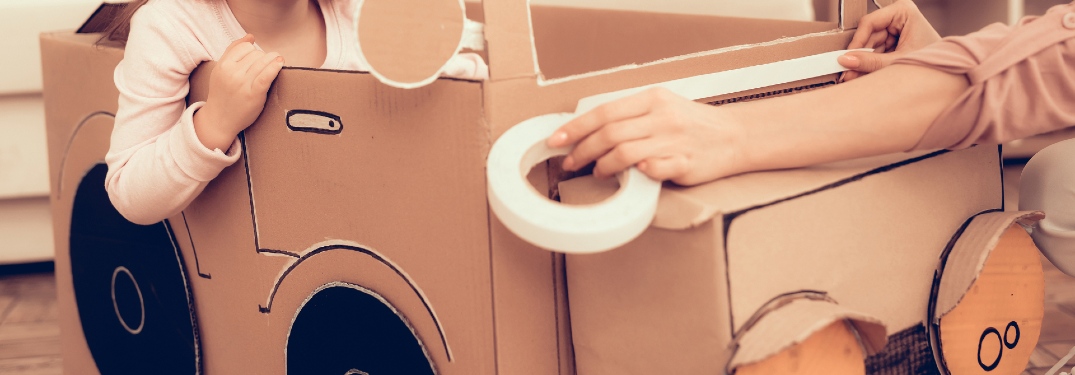 A car is built from cardboard and masking tape.