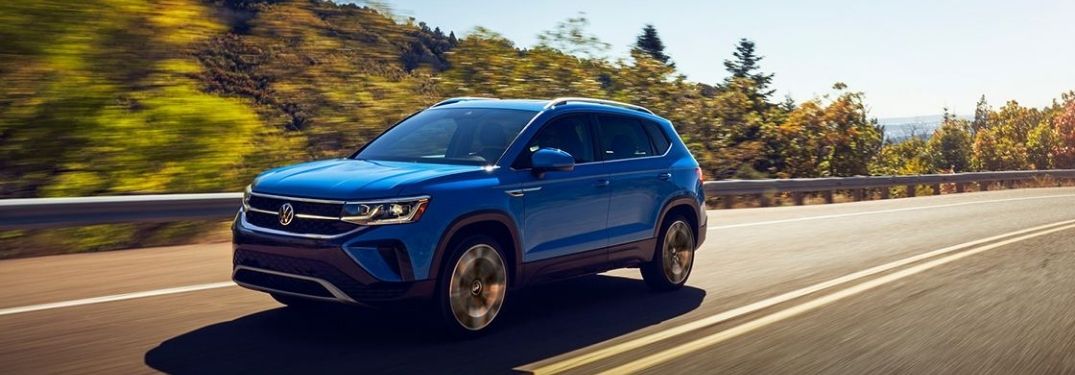 A blue 2022 Volkswagen Taos driving on a highway.