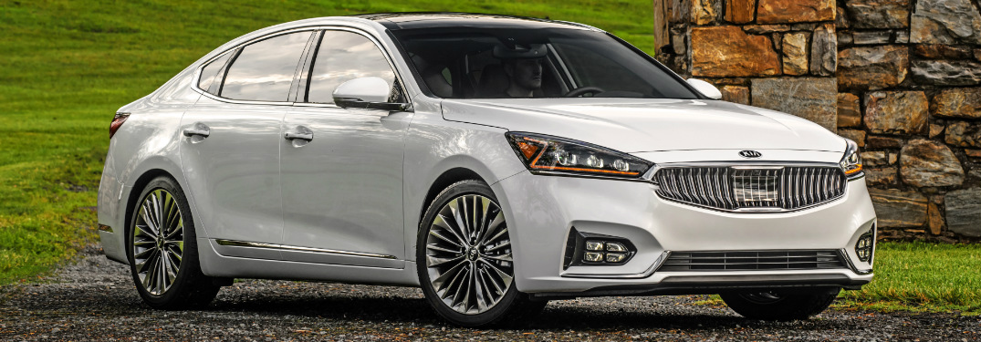 White 2018 Kia Cadenza with a Grassy Hill in the Background