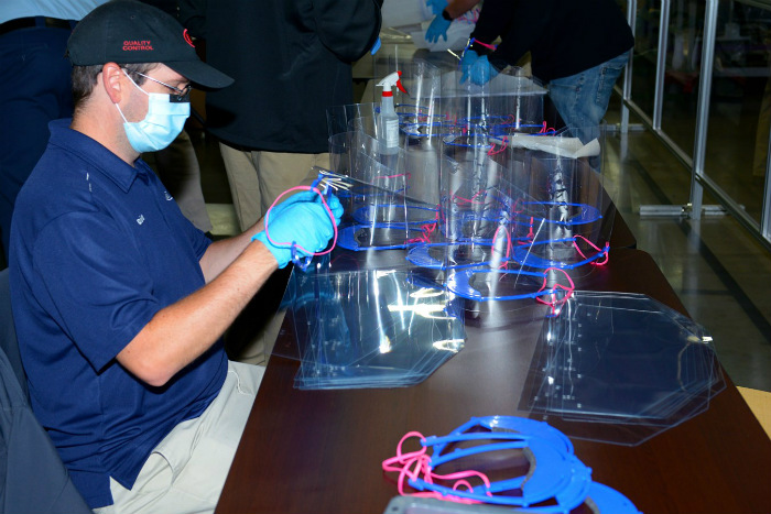 A Kia employee making face shields for healthcare professionals on the frontlines of fighting COVID-19