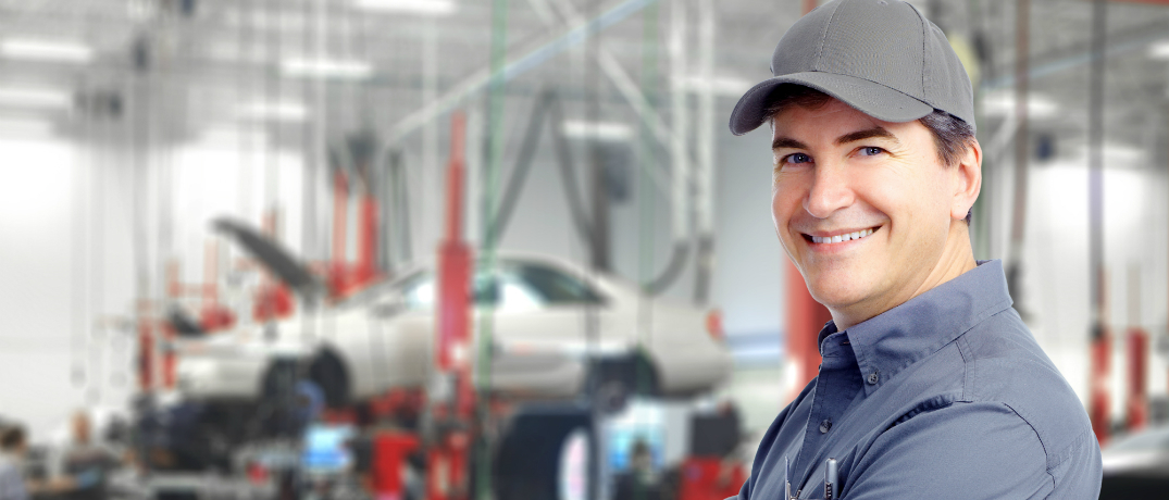 Mechanic Standing in front of a Car Lift