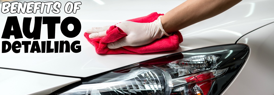 Person hand wiping white car clean with text of benefits of auto detailing