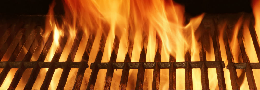 empty close up of grates on a flaming grill
