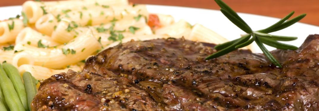 a rib eye steak with pasta and vegatables