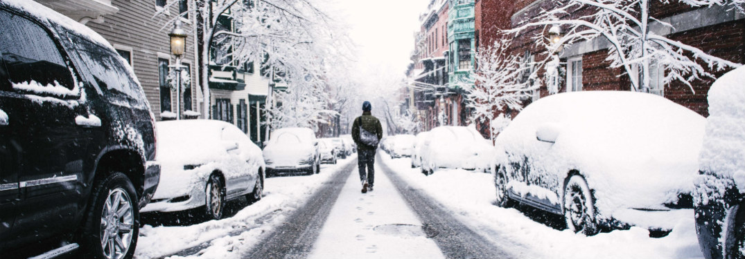 person walking down middle of a snow covered road