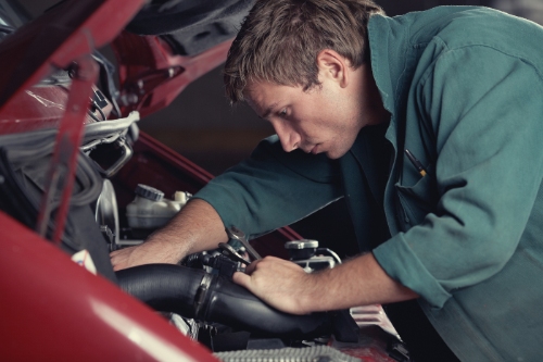 mechanic working on car engine