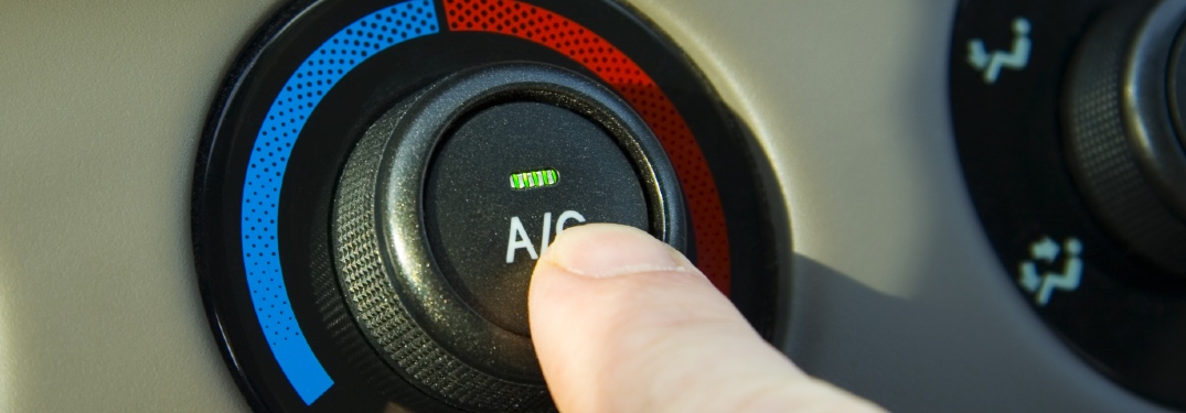 person pushing A/C button in car