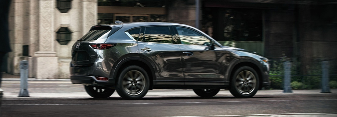 2020 CX-5 driving by imposing city building