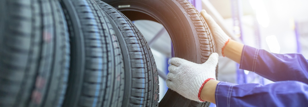 person pulling new tire from tire rack