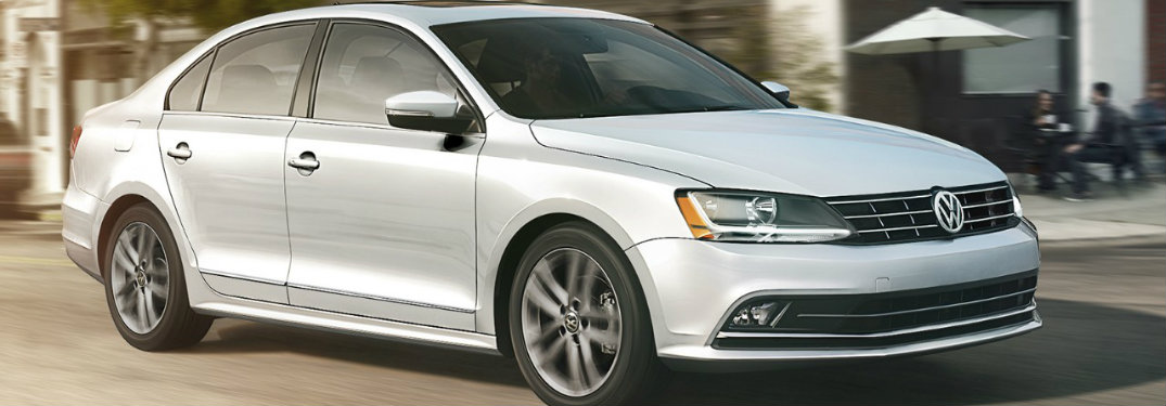 White-2018-Volkswagen-Jetta-driving-in-front-of-cafe